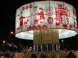 A large round white fabric band decorated with red figures and images for Tết