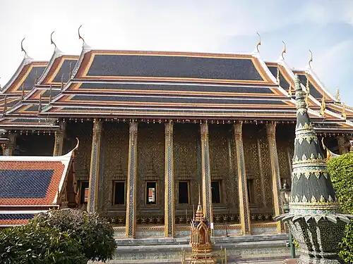 Side view of the ubosot, featuring its gilded columns and intricate mosaic decoration.