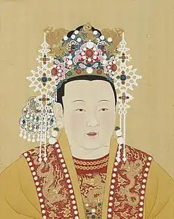 Empress Xu wears red and yellow robes and a crown decorated with pearls and gold dragons and phoenixes