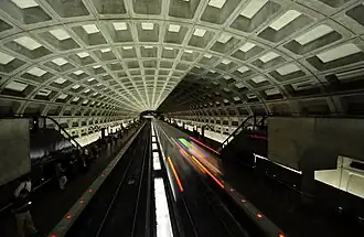 A train departs from McPherson Square (opened 1977), which has an original ceiling vault design.