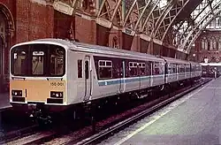 A train, painted in a service livery, as photographed from the other side of a bay platform. In the background is the grand roof of St Pancras