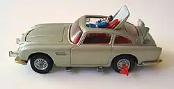 a silver-coloured toy car showing a plastic man being ejected through the roof