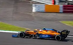 Norris driving an orange McLaren MCL35M
