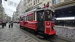 A nostalgic tram on İstiklal Avenue, decorated for the 112th anniversary of the city's electric powered tram service which began in 1914, replacing the horse-drawn tram service between 1872 and 1914[388]