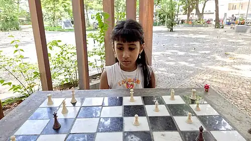 A six-year-old girl playing chess at a public square in Rio de Janeiro, Brazil.