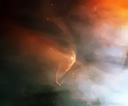Patchy orange and blue nebulosity against a black background, with a curved orange arc wrapping around a star at the center.
