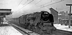 A black-and-white photo of an express locomotive in the snow, taken from the front