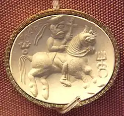 Kushan Carnelian seal representing the "ΑΔϷΟ" (adsho Atar), with triratana symbol left, and Kanishka the Great's dynastic mark right