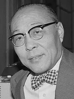 Black-and-white photograph of An Wang seated at a desk