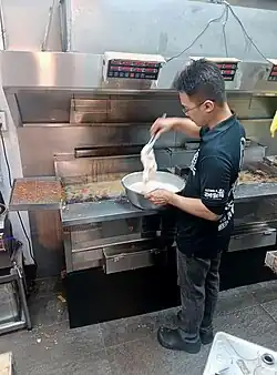 A man deep frying chicken cutlets