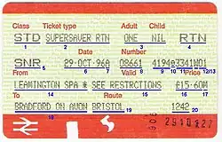 A yellow-background paper ticket with orange margins at the top and bottom, with a double arrow in the bottom left. The different labels on the ticket are underlined and numbered. The ticket is a standard class supersaver return from Leamington Spa to Bradford on Avon via Bristol.