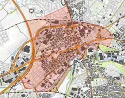 An OS map of the area, a rough cuboid of which is shaded red to show roughly the boundaries of Ashton. To the left this is a large road, and to the bottom a river.
