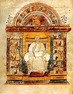 An illuminated manuscript illustration of a central seated figure holding an open book. He is flanked by two colonnades filled with small scenes. Over the central figure is an arch which surmounts a winged bull.