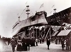 Photograph of Kearsarge on her slipway. Kentucky is on her right, and crowds surround both.