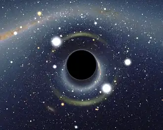 A black circle, center, surrounded by three bright white blobs of light and the orange-coloured Milky Way distorted into an ark around it. The background is a starry sky with a second image of the Milky Way, not warped, visible in the top left corner.