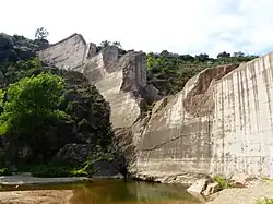 The remains of a large dam, which has been cracked and broken by some event.