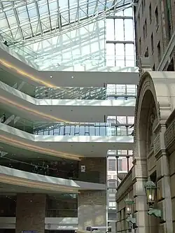 vaulted tile entrance arch to a large building enclosed inside a modernist multi-story atrium