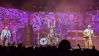 Blink-182 performing in Palm Desert in 2025. Left to right: Mark Hoppus, Travis Barker, and Tom DeLonge