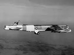 Black-and-white photo of a B-52 in flight with its vertical stabilizer sheared off.
