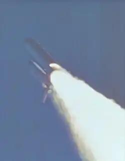 Space Shuttle challenger in-flight with an anomalous plume of fire from the side of its right solid rocket booster