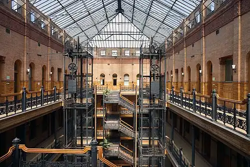 Interior of the Bradbury Building, with its exposed staircases and free-standing hydraulic elevators, Los Angeles, USA, by George Herbert Wyman, 1889-1893[249]