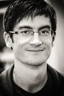 Dark-haired man with glasses smiling