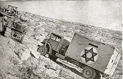 A bulldozer tows an ambulance on the Burma Road, June 1948