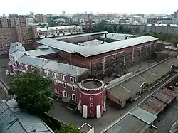 Photograph of a large prison with red walls, surrounded by the city of Moscow