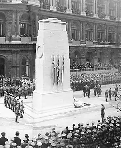 Black and white photograph of a crowd gathered round a monument