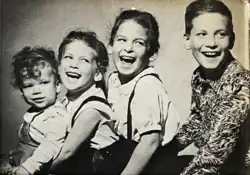 A line of four children smiling.