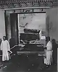 State of the burial chamber of the Empress Dowager Cixi's tomb, photographed as part of the post-1928 looting investigations. Her discarded corpse, burial shroud and damaged coffin are visible in the background.
