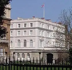 Photograph of the white building with a Union flag flying over it