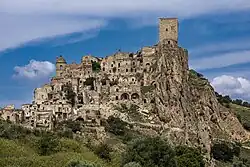 Ruined stone buildings of the medieval village of Craco on a hilltop