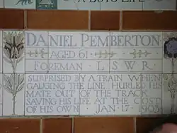 A tablet formed of five tiles of varying sizes, bordered by yellow and blue flowers in an art nouveau style