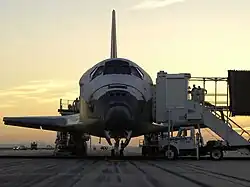 The Space Shuttle Discovery on the runway as ground crews work to get the crew out of the orbiter
