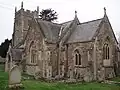 Stone building with square tower and arched windows.