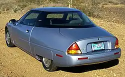 The rear three-quarters view of a car with a hidden rear wheel.