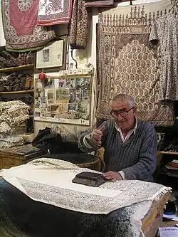 A man manually printing patterns on a carpet