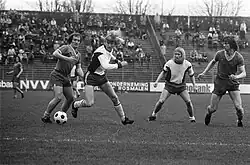 Advocaat (left, in white) dribbles a ball during his time playing for FC Den Haag in 1973. Photo is in black and white.
