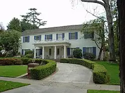 A white house with blue shutters is pictured