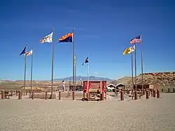 Flags surrounding the Four Corners Monument. In clockwise order starting from the frontmost flag, the state flag of Arizona, flag of the Navajo Nation, pre-2011 flag of Utah, Navajo nation (second instance) Ute Mountain Ute Tribe Reservation, Colorado, New Mexico, Navajo Nation (third instance), and the flag of the United States.