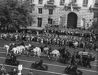 A parade with horses heading through a street