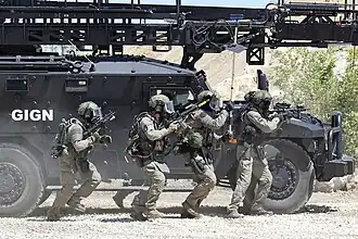 GIGN unit progressing in front of a Sherpa assault ladder vehicle during training