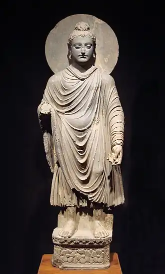The Buddha wearing kāṣāya robes, originating from ancient India. Fully ordained Buddhist monks and nuns wore these robes.