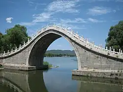 A masonry moon bridge showing the buttressing approach ramps that take the horizontal thrust of the arch