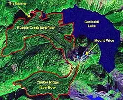 A falsely coloured satellite image of mountainous terrain with a crescent-shaped lake