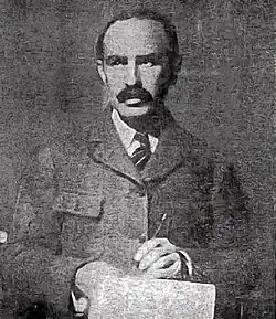 Soper, wearing a jacket and tie
