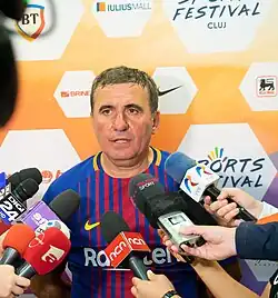 Man in a Barcelona shirt being with microphones held in front of him