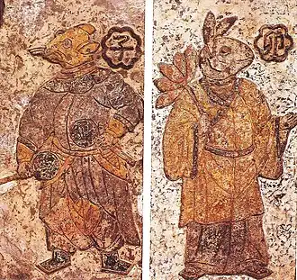 Painted and incised ceramic tiles with anthropomorphic animal figures, including a rat on the left and a rabbit on the right wearing clothes and holding objects in their hands