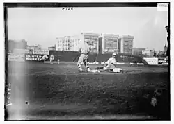 A black-and-white photograph of a baseball player sliding into a base